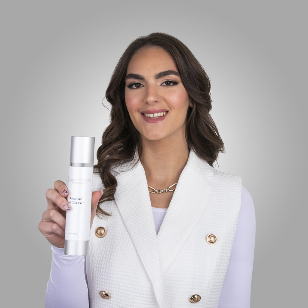 Picture of Pessy Malamud, President of Skin Solutions Technology LLC, holding a sample of Skin Solutions Technology botanical gel cleanser.